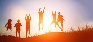 Silhouettes of children jumping and playing